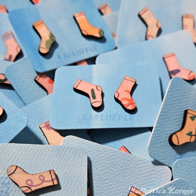 A Pile of wooden earrings that look like funky socks.