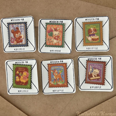 6 wooden stamp pins with varied designs on a brown letter background.